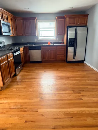 a large white kitchen with wooden floor