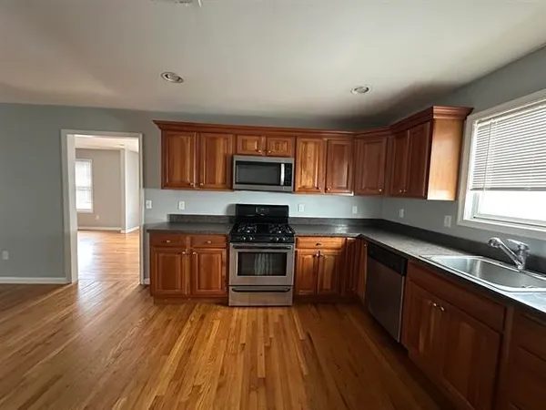 a kitchen with granite countertop wooden floors and black stainless steel appliances