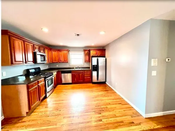 a large kitchen with stainless steel appliances granite countertop a refrigerator and a sink