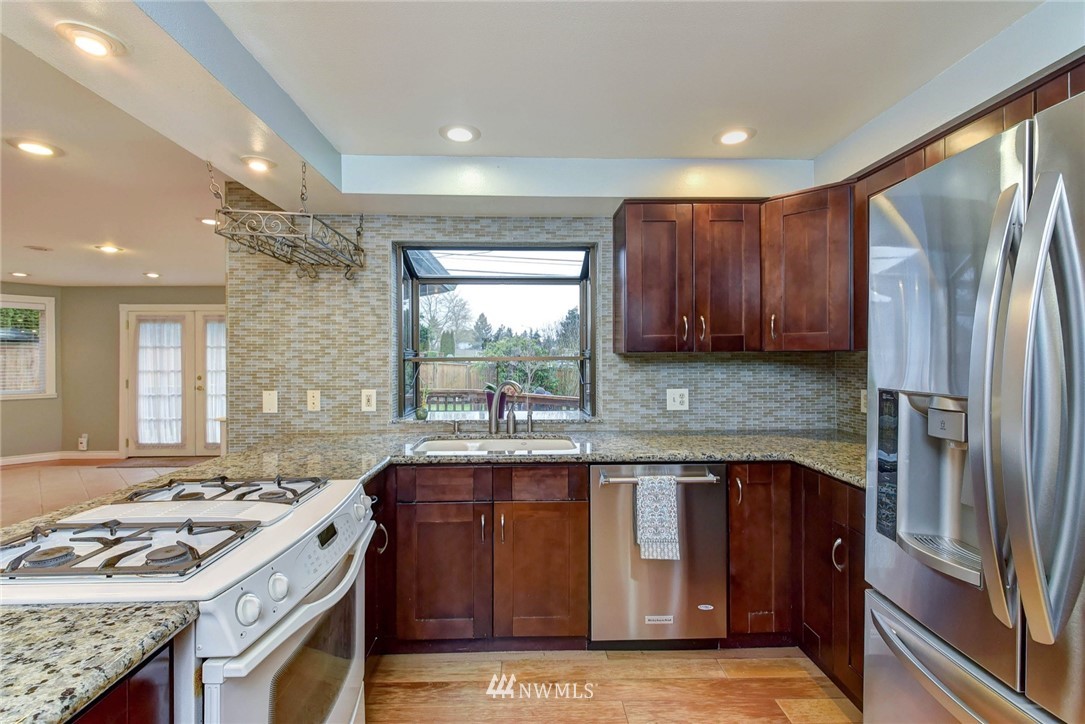 23814 23rd Drive Southeast Bothell, WA 98021 - Photo 5 of 26 a kitchen with stainless steel appliances granite countertop a stove a sink dishwasher and a refrigerator
