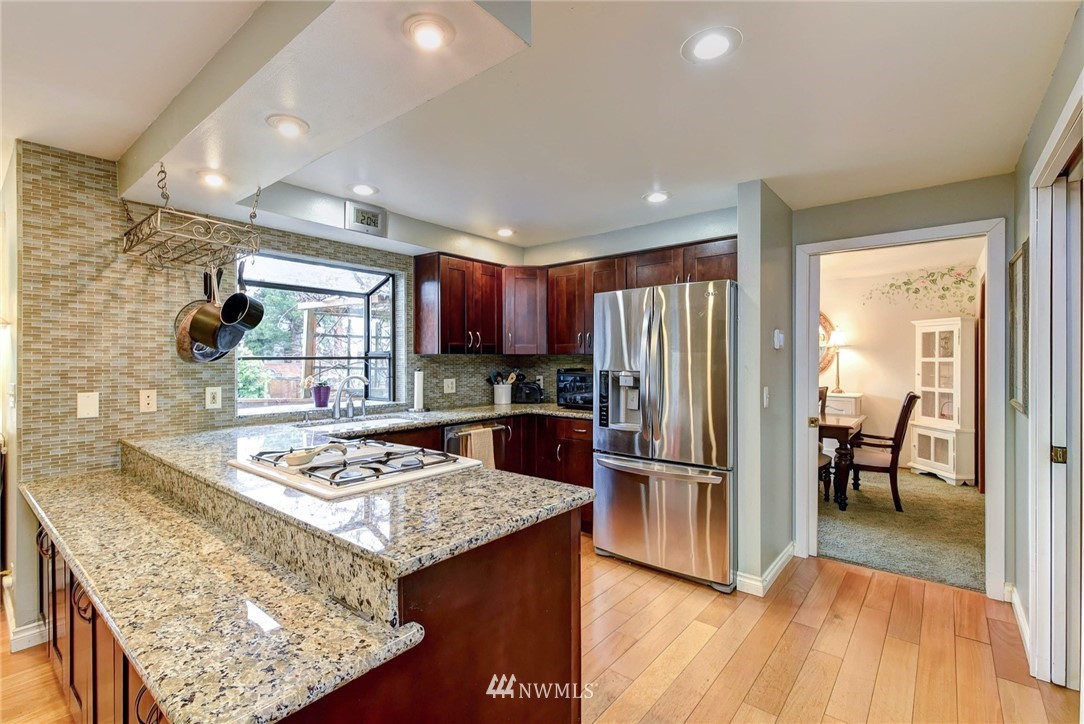 23814 23rd Drive Southeast Bothell, WA 98021 - Photo 6 of 26 a kitchen with stainless steel appliances granite countertop sink stove refrigerator and wooden floor