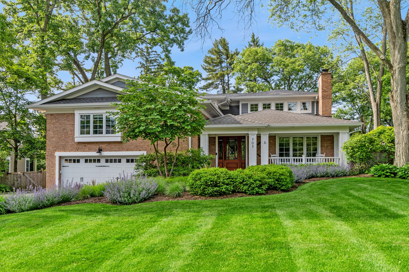 a front view of a house with a yard and trees