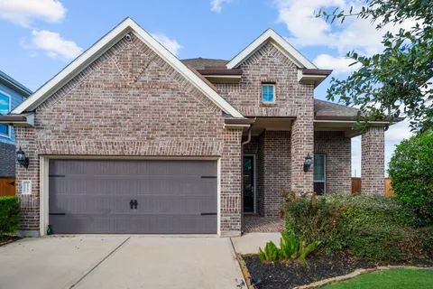 a front view of a house with a garden and garage
