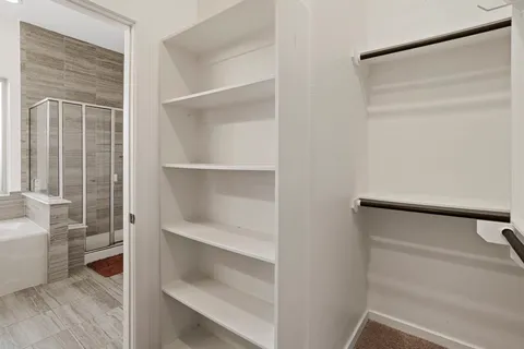 a view of walk in closet with empty racks