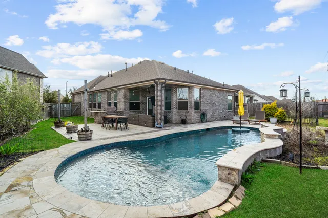 a view of a house with swimming pool and sitting area