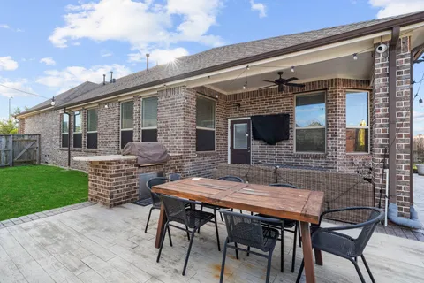 a backyard of a house with barbeque oven table and chairs