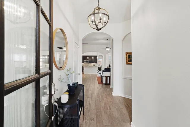an empty room with wooden floor mirror and outdoor view