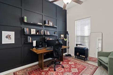 a view of a workspace with furniture and a window