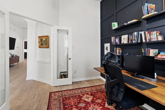a view of a workspace with furniture and a book shelf