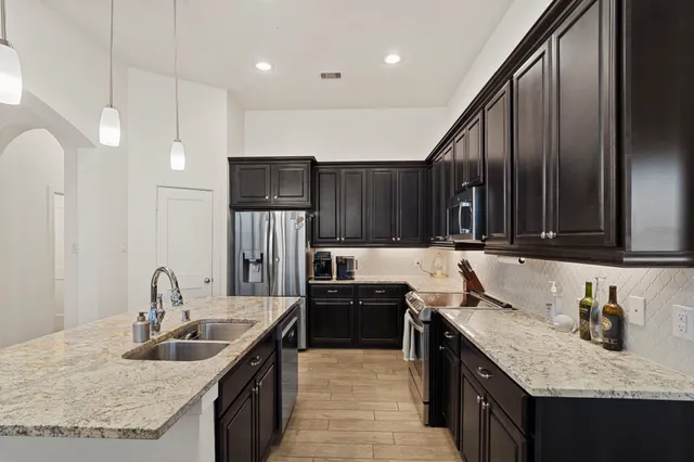 a kitchen with stainless steel appliances granite countertop a sink stove and cabinets