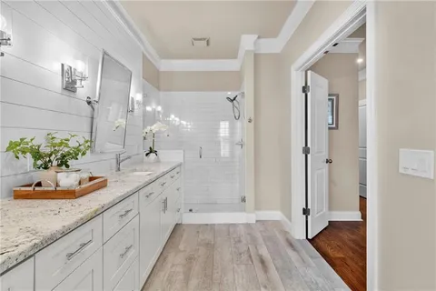 a bathroom with a granite countertop shower a sink and a mirror
