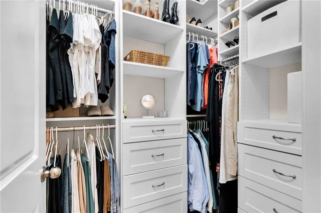 a view of walk in closet with clothes and shoes