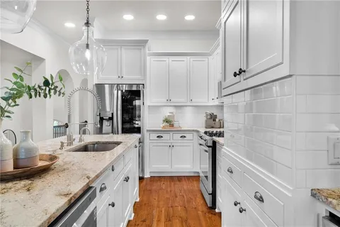 a kitchen with stainless steel appliances granite countertop a sink stove and refrigerator