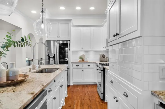 a kitchen with stainless steel appliances granite countertop a sink stove and refrigerator