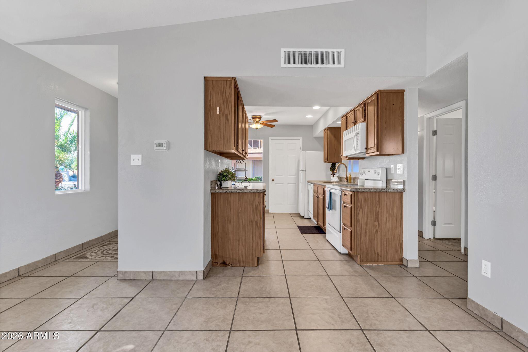 725 South Power Road, Unit 101 Mesa, AZ 85206 - Photo 16 of 38 a kitchen with stainless steel appliances a refrigerator sink and cabinets
