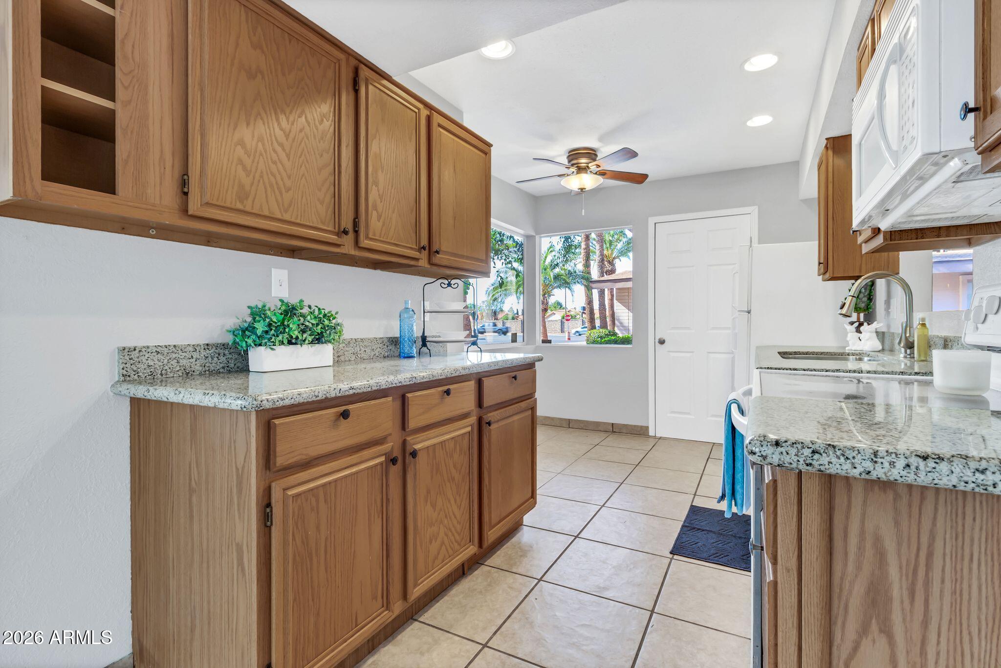 725 South Power Road, Unit 101 Mesa, AZ 85206 - Photo 21 of 38 a kitchen with stainless steel appliances granite countertop a sink stove and cabinets