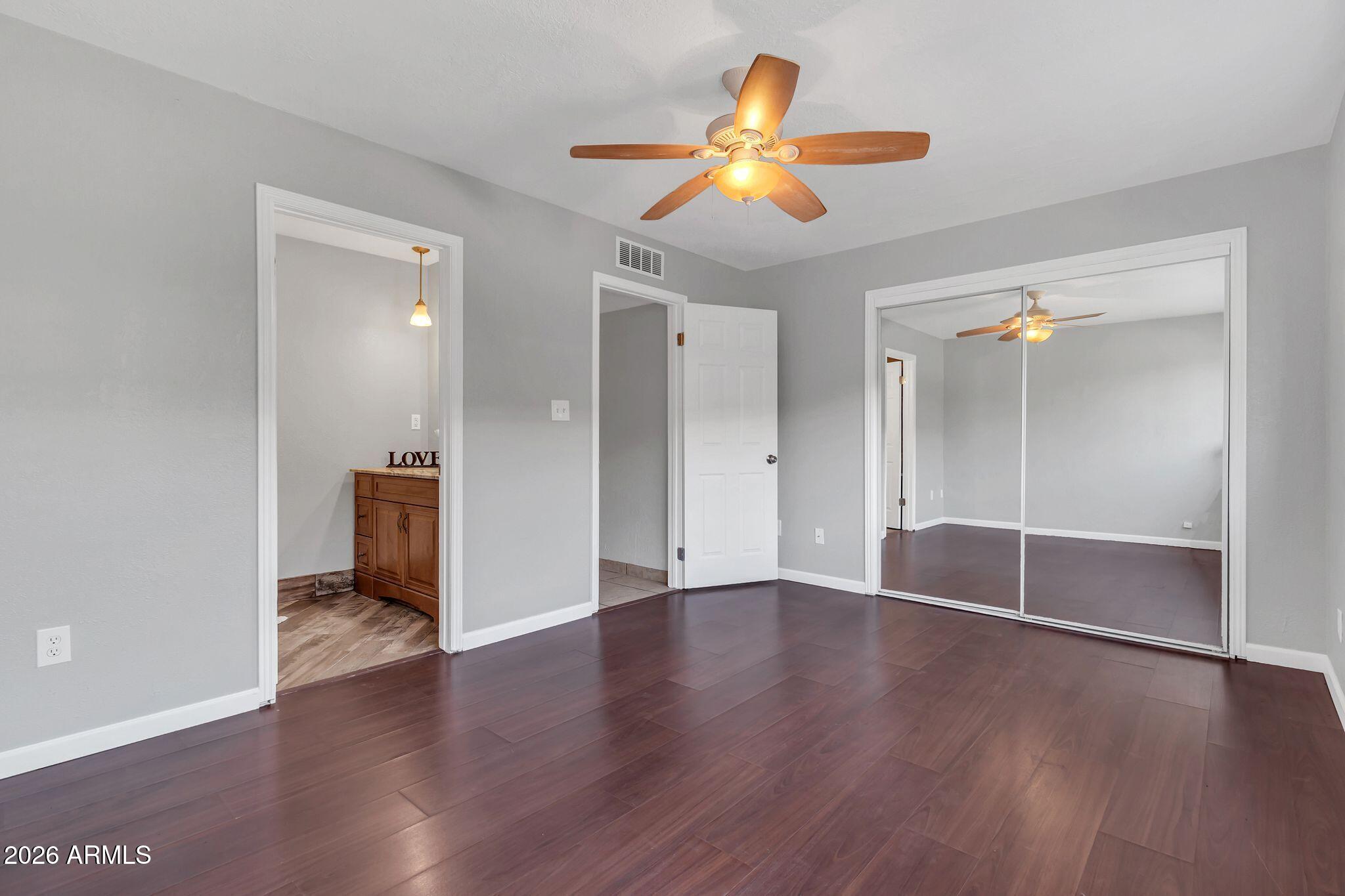 725 South Power Road, Unit 101 Mesa, AZ 85206 - Photo 23 of 38 an empty room with wooden floor and a ceiling fan