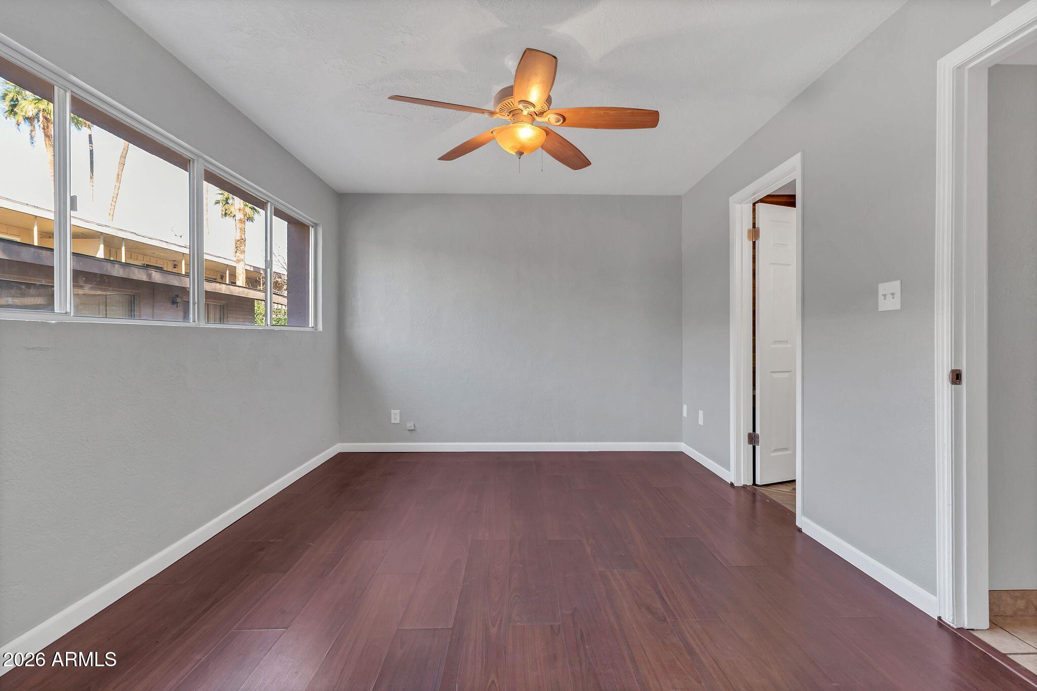725 South Power Road, Unit 101 Mesa, AZ 85206 - Photo 24 of 38 an empty room with wooden floor and windows
