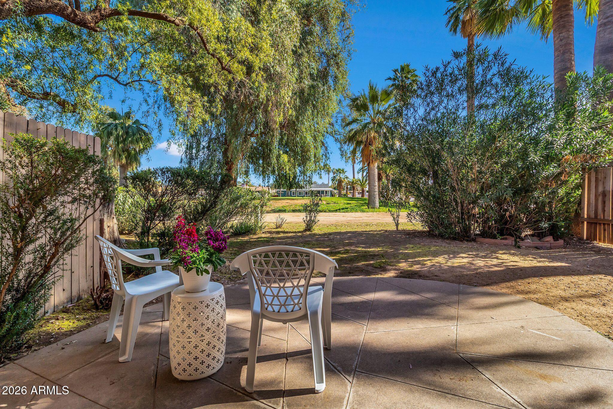 725 South Power Road, Unit 101 Mesa, AZ 85206 - Photo 32 of 38 a patio with table and chairs and potted plants