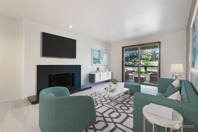 a living room with furniture a flat screen tv and a fireplace