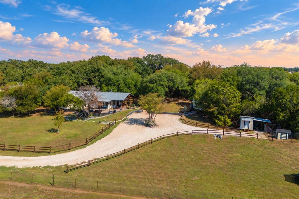 384 Ft Graham Road Waco, TX 76705 - Photo 32 of 36 Expansive gravel driveway leading to the property, surrounded by a wood-rail fence
