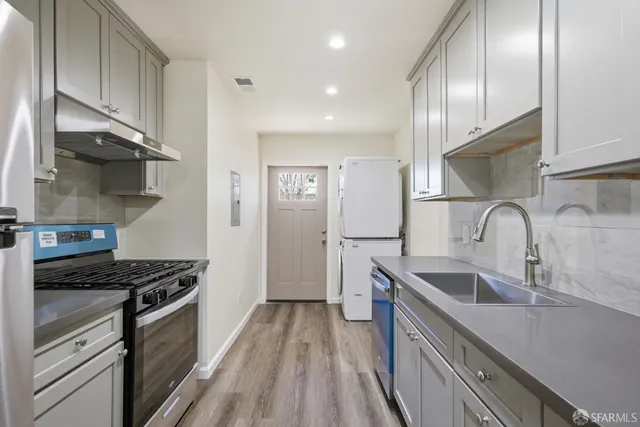 a kitchen with kitchen island granite countertop a sink stainless steel appliances and cabinets