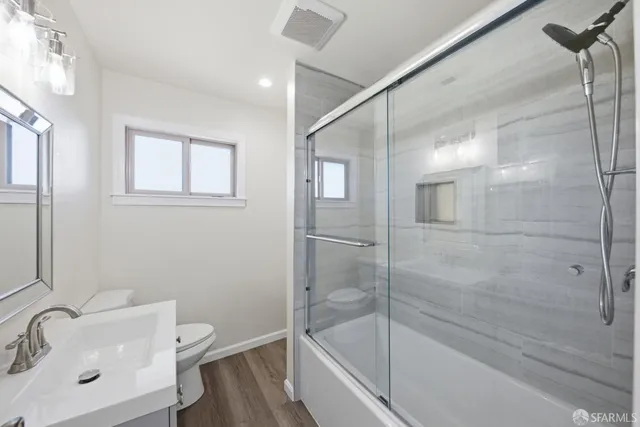 a bathroom with a bathtub shower sink vanity and toilet