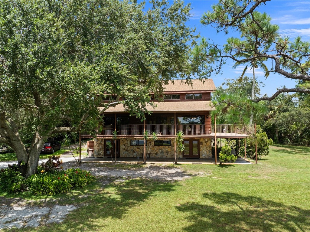 5051 Tozour Road Fort Pierce, FL 34946 - Photo 2 of 31 a view of a house with a large window and a tree