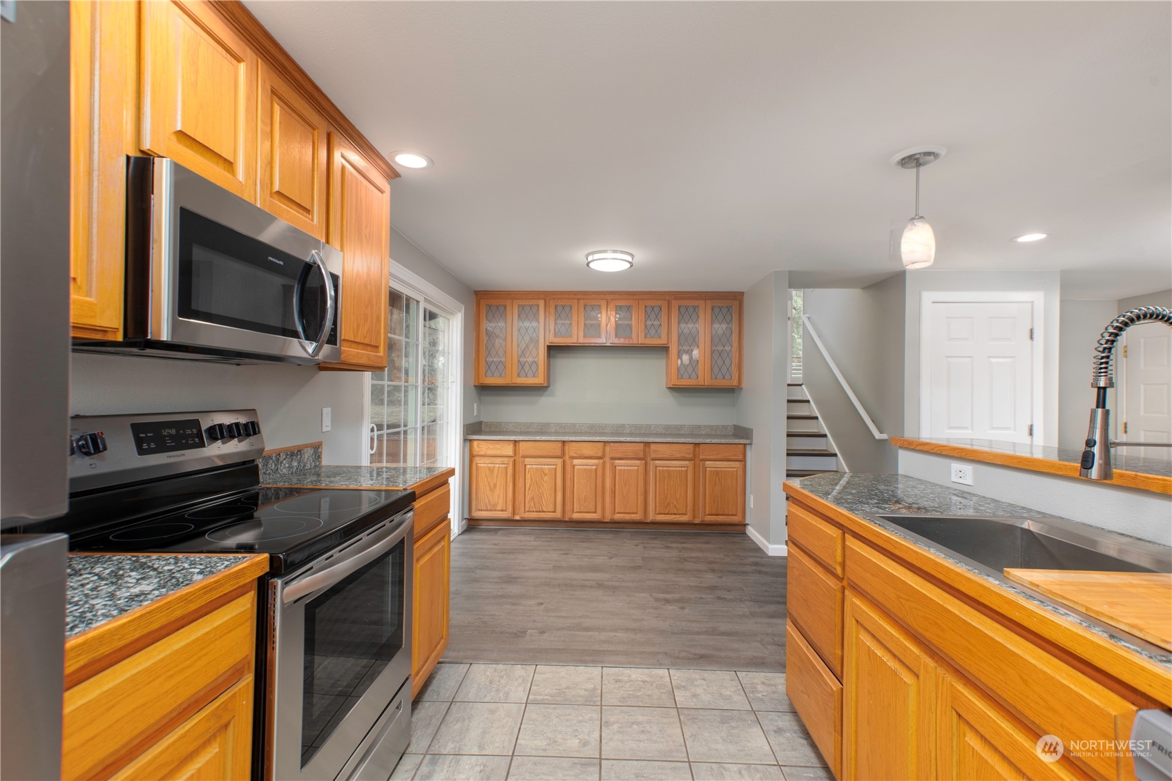 14092 Southeast 190th Street Renton, WA 98058 - Photo 12 of 27 a kitchen with stainless steel appliances granite countertop a stove a sink and a microwave