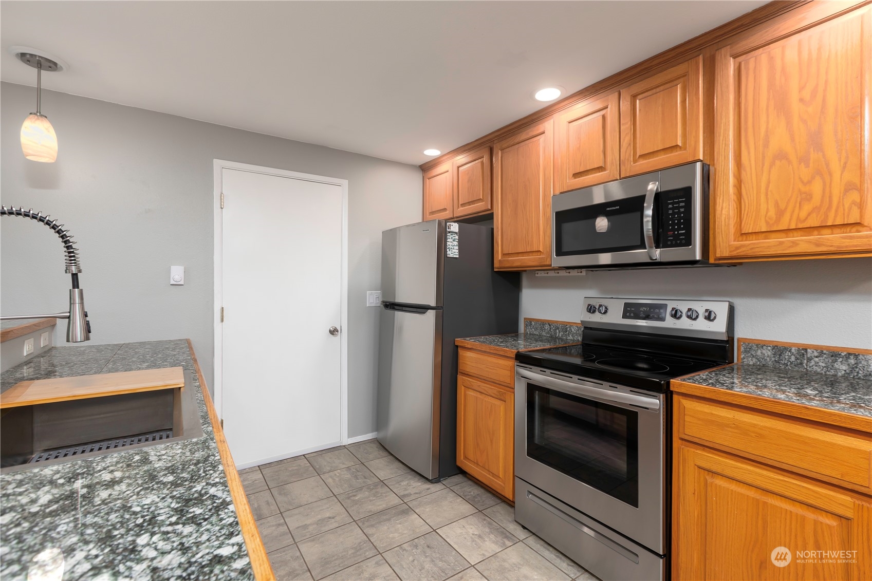 14092 Southeast 190th Street Renton, WA 98058 - Photo 13 of 27 a kitchen with stainless steel appliances granite countertop a stove microwave and refrigerator