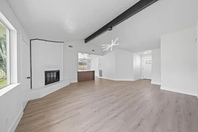 a view of a livingroom with wooden floor and a fireplace