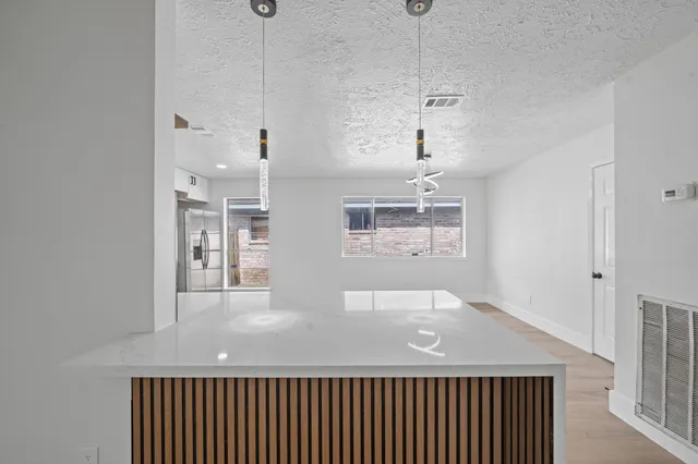 a hallway with a chandelier fan and wooden floor