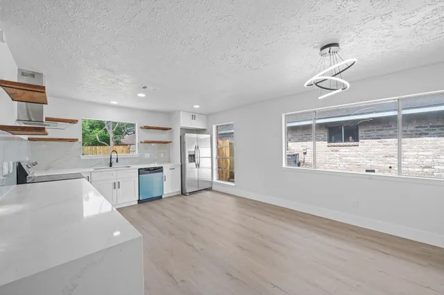 a kitchen with granite countertop a sink stainless steel appliances and cabinets