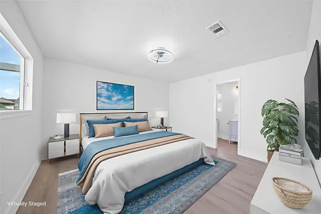 a bedroom with a bed and a potted plant