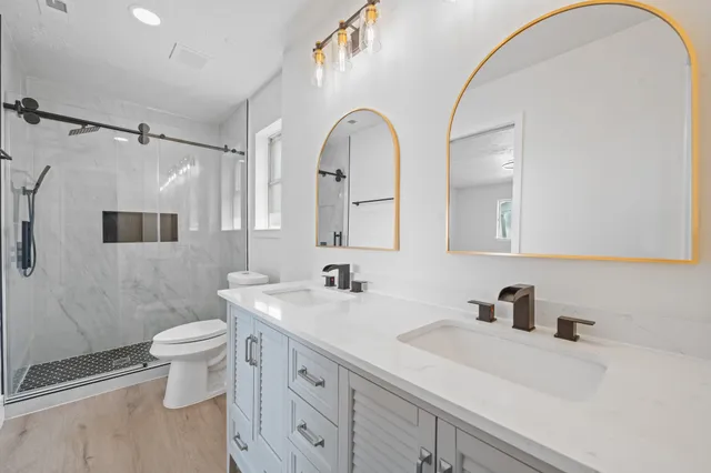 a bathroom with a sink a toilet and a mirror