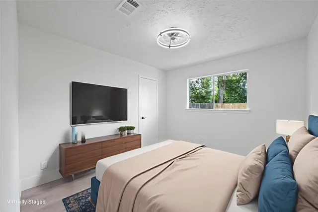 a bedroom with a bed and a flat screen tv