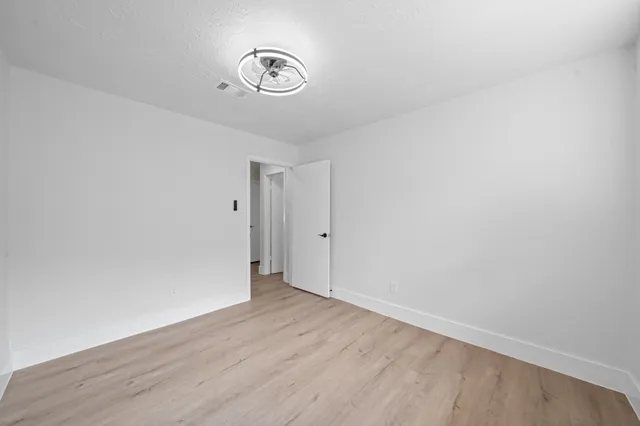 a view of a room with wooden floor and a window