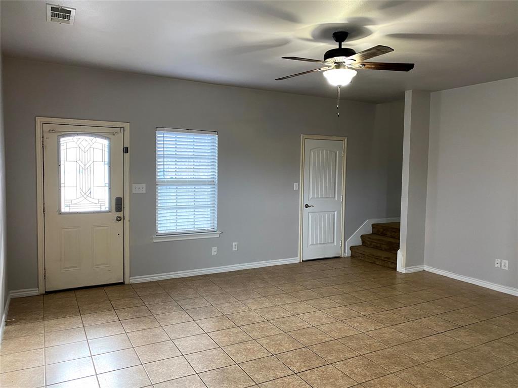 906 Parkplace Ridge Princeton, TX 75407 - Photo 9 of 31 Neutral gray wall paint with white trim, ceramic tile flooring, a front door with decorative glass, and a ceiling fan with integrated lighting