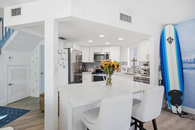 a kitchen with stainless steel appliances kitchen island granite countertop a refrigerator and microwave