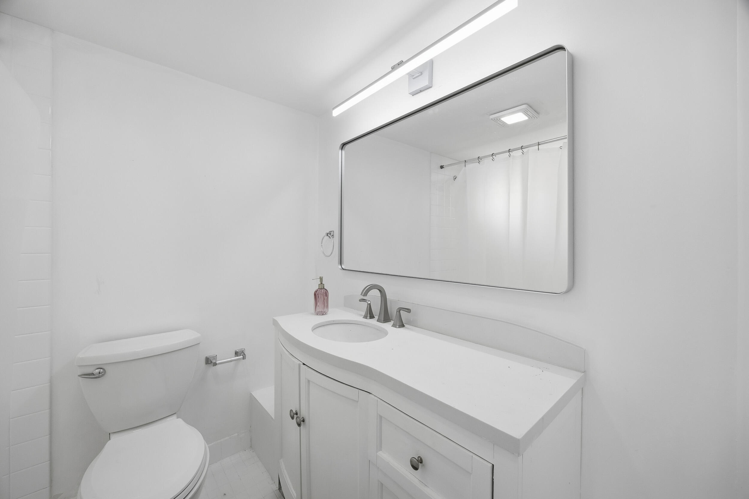 153 Seabreeze Circle Jupiter, FL 33477 - Photo 26 of 36 a bathroom with a toilet a sink a mirror and vanity