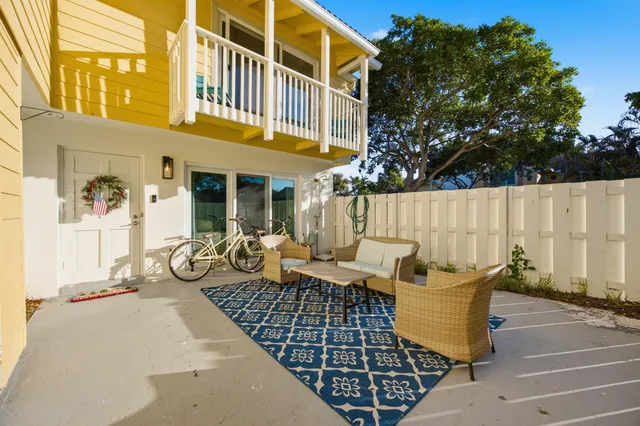 a view of a patio with couches table and chairs and potted plants