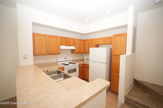 a kitchen with a refrigerator a stove a sink and a microwave