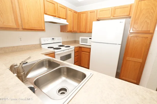 a kitchen with a refrigerator sink stove and cabinets