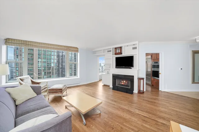 a living room with furniture a flat screen tv and a fireplace