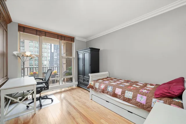 a bedroom with a bed and large windows