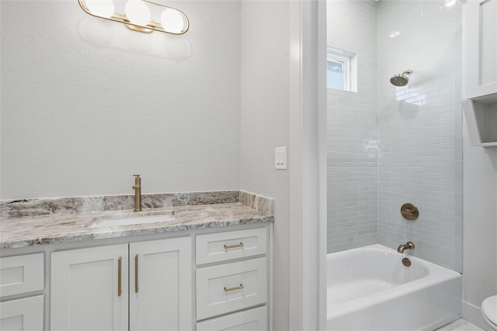 348 Lacek Mill Road China Spring, TX 76633 - Photo 15 of 40 a bathroom with a granite countertop sink a mirror and a bathtub