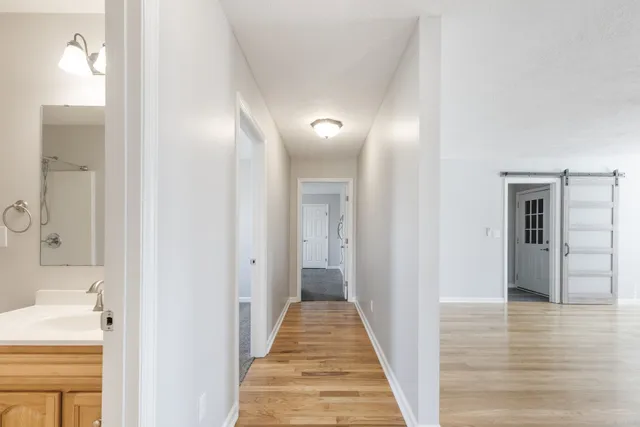 a view of a hallway with wooden floor and staircase