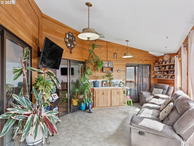 a living room with patio furniture and a ceiling fan
