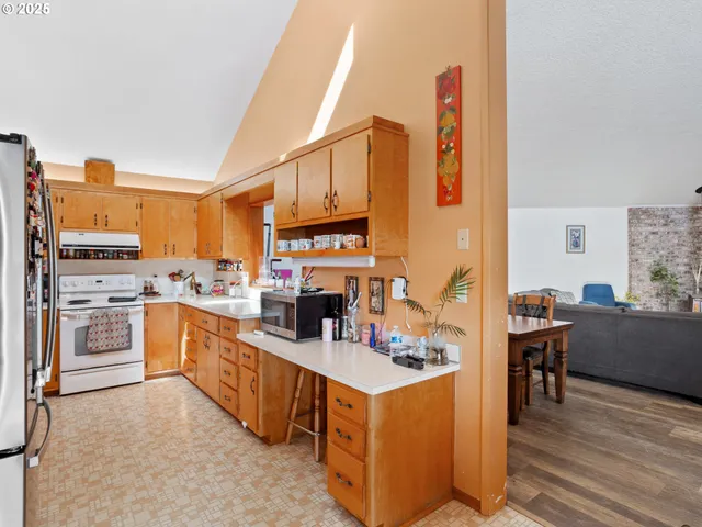 a kitchen with stainless steel appliances kitchen island granite countertop a stove top oven a sink a counter top space and cabinets