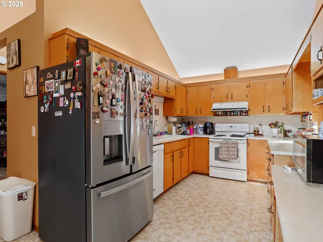 a kitchen with stainless steel appliances granite countertop a refrigerator sink and stove
